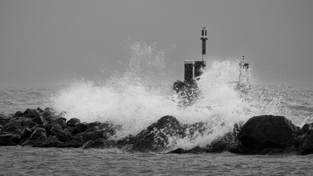Een hevige storm doet de golven van het Markermeer opspatten tegen de stenen golfbrekers