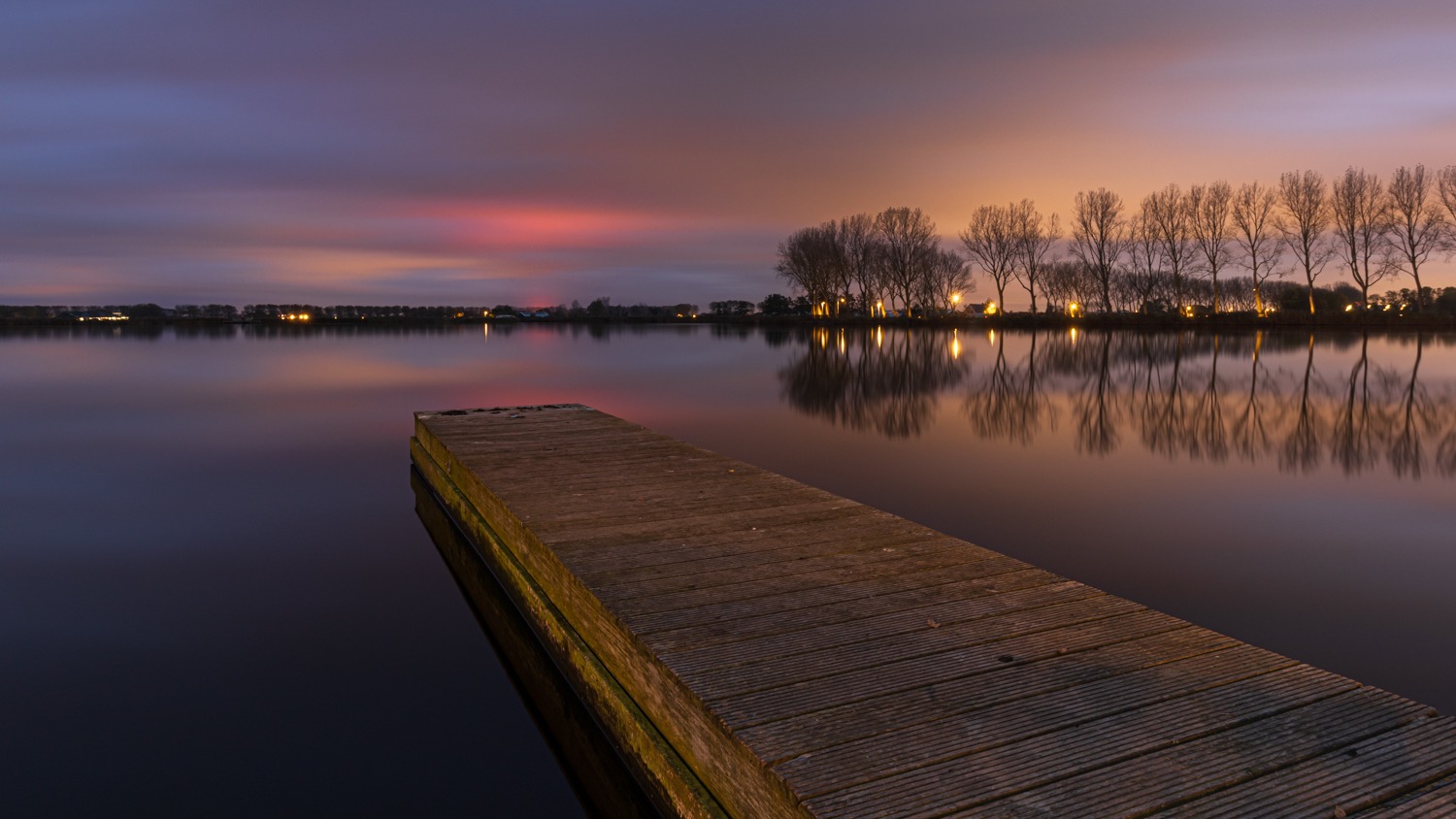 Avondfotografie bij het meer van Dirkshorn, met een kleurrijke lucht en mooie reflectie van de bomenrij.